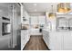 Spacious kitchen features white cabinetry, stainless steel appliances, and a large island with bar seating at 8691 S Sicily Ct, Aurora, CO 80016