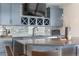 Stylish kitchen area with wine storage, modern cabinetry, sleek countertops, and stainless steel appliances at 8691 S Sicily Ct, Aurora, CO 80016