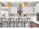 Modern kitchen features white cabinetry, stainless steel appliances, and a stylish island with bar seating at 8691 S Sicily Ct, Aurora, CO 80016