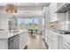 Bright kitchen featuring white cabinets, stainless appliances, and an open layout with views of the dining area at 8691 S Sicily Ct, Aurora, CO 80016