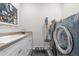 Well-equipped laundry room with modern washer, dryer, sink, patterned tile floors and ample countertop space at 8691 S Sicily Ct, Aurora, CO 80016
