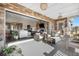 Beautiful covered patio with stone walls, a comfortable seating arrangement, and an open view to the living area at 8691 S Sicily Ct, Aurora, CO 80016