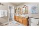 Bathroom with double sinks, wood cabinets, and a separate toilet room at 11076 W Dumbarton Cir, Littleton, CO 80127