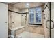 Elegant bathroom featuring a marble-tiled walk-in shower with a bench and dual showerheads at 1350 Lawrence St # 2F, Denver, CO 80204