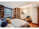 Bedroom with hardwood floors, built-in bookshelves and a large window at 1350 Lawrence St # 2F, Denver, CO 80204