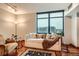 Cozy living room with large window offering city views, hardwood floors, and comfortable seating at 1350 Lawrence St # 2F, Denver, CO 80204