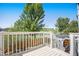 Outdoor deck area with white railing, offering a serene view of the lush backyard and surrounding greenery at 9200 W Indore Dr, Littleton, CO 80128