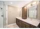 Well-lit bathroom with a double sink vanity and a modern glass shower at 9200 W Indore Dr, Littleton, CO 80128