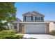 Charming two-story home featuring a covered porch, manicured lawn, and brick accents during daytime at 9200 W Indore Dr, Littleton, CO 80128