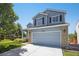 Charming two-story home featuring a covered porch, manicured lawn, and brick accents at 9200 W Indore Dr, Littleton, CO 80128