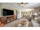 Open concept living area connected to kitchen and dining featuring a TV and fireplace at 9200 W Indore Dr, Littleton, CO 80128