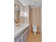 Charming powder room with decorative wallpaper, oval mirror, and stylish fixtures at 7058 S Madison Way, Centennial, CO 80122