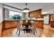 Dining area with brick flooring, a wooden table with chairs, and a large bay window at 7058 S Madison Way, Centennial, CO 80122