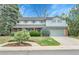 Charming two-story home featuring a well-manicured lawn, mature trees, and an attached two-car garage at 7058 S Madison Way, Centennial, CO 80122
