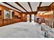 Spacious game room featuring wood paneling, built-in cabinets, and a comfortable seating area at 7058 S Madison Way, Centennial, CO 80122