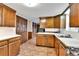 Kitchen featuring brick flooring, wood cabinets, and white countertops at 7058 S Madison Way, Centennial, CO 80122