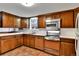 Cozy kitchen with brick flooring, wood cabinets, stainless appliances, and white countertops at 7058 S Madison Way, Centennial, CO 80122