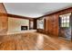 Cozy living room with hardwood floors, wood paneling, brick fireplace, and built-in shelving at 7058 S Madison Way, Centennial, CO 80122