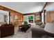 Comfortable living room with hardwood floors, wood paneling, and fireplace with built-in shelving at 7058 S Madison Way, Centennial, CO 80122