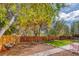 A well-maintained backyard features beautiful trees and a wood fence at 5450 Mohawk Rd, Littleton, CO 80123