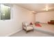 Finished basement space with carpeted platform, chair, egress window and natural light at 5450 Mohawk Rd, Littleton, CO 80123