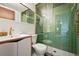 Modern bathroom features an avocado green tile shower, a vanity, and ample lighting at 5450 Mohawk Rd, Littleton, CO 80123