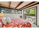Bright bedroom featuring exposed beams, a red floral bedspread, and sliding glass door to the outdoor deck at 5450 Mohawk Rd, Littleton, CO 80123