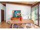 Bright dining room with wooden beams, sliding glass doors, and modern art at 5450 Mohawk Rd, Littleton, CO 80123