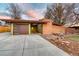 Mid-century modern home with brick facade, flat roof, and attached garage at 5450 Mohawk Rd, Littleton, CO 80123