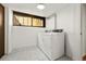 Efficient laundry room is equipped with a washer and dryer, plus a small window at 5450 Mohawk Rd, Littleton, CO 80123