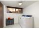 Bright laundry room with modern washer and dryer, gray storage containers, and speckled floor at 5450 Mohawk Rd, Littleton, CO 80123