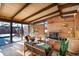 Bright living room with floor-to-ceiling windows, brick fireplace, and wood-beamed ceiling at 5450 Mohawk Rd, Littleton, CO 80123