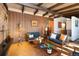 Cozy living room featuring wood paneling, exposed beam ceiling, and comfortable mid-century furniture at 5450 Mohawk Rd, Littleton, CO 80123