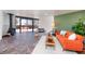 Living room featuring stone floors, fireplace and orange sofa, leading to an outdoor patio at 5450 Mohawk Rd, Littleton, CO 80123