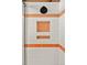 Modern shower featuring white tile, orange accents, and recessed shelving at 5450 Mohawk Rd, Littleton, CO 80123
