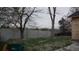 View of a green backyard with a tall concrete fence bordering the property at 3091 S Holly Pl, Denver, CO 80222