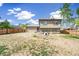 Expansive backyard with partial grass, featuring a wood fence, dog house, and two-story home at 9605 Orangewood Dr, Thornton, CO 80260