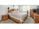 Cozy bedroom with a wooden bed frame, complemented by matching dressers and soft, neutral-toned bedding at 9605 Orangewood Dr, Thornton, CO 80260
