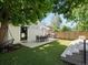 Spacious backyard with outdoor dining and seating areas, artificial turf, and mature trees at 332 S Franklin St, Denver, CO 80209