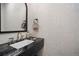 Powder room features a black marble countertop, stylish faucet, and decorative wallpaper at 332 S Franklin St, Denver, CO 80209