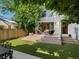 View of home's exterior from backyard patio featuring outdoor living space with lush lawn and mature trees at 332 S Franklin St, Denver, CO 80209