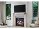 Close-up of a modern fireplace with a mantel, a mounted TV, and natural light from the adjacent windows at 332 S Franklin St, Denver, CO 80209