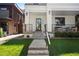 Inviting front yard with a walkway leading to the front door, black railings, and manicured landscaping at 332 S Franklin St, Denver, CO 80209
