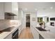 Modern kitchen boasts sleek white cabinetry, stainless steel appliances, and a stylish island with seating at 332 S Franklin St, Denver, CO 80209