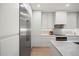 Contemporary kitchen with stainless steel refrigerator, custom cabinets, and a center island with a cooktop at 332 S Franklin St, Denver, CO 80209