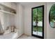 Bright mud room with tile floors, bench seat, and black framed door leading to backyard at 332 S Franklin St, Denver, CO 80209
