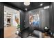 Stylish office with dark grey paneled walls, modern lighting, and desk, with a partial view of the foyer at 332 S Franklin St, Denver, CO 80209