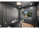 Chic dark grey office features paneled walls, a modern desk, and a large window with a view at 332 S Franklin St, Denver, CO 80209