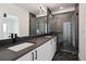 Elegant bathroom with dark vanity, double sinks, and frameless shower at 1248 N Tennyson St, Denver, CO 80204