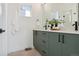 Modern bathroom with green vanity, double sinks, and black accents at 1248 N Tennyson St, Denver, CO 80204